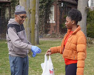 A TENN student delivers a bag of food to a community member.