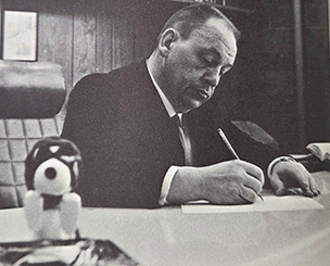 Dean Lawrence Canjar writes at his desk.