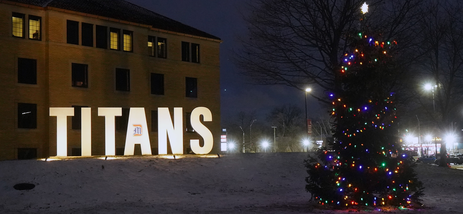 A Christmas tree next to the Titans sign, both lit up for the holidays.