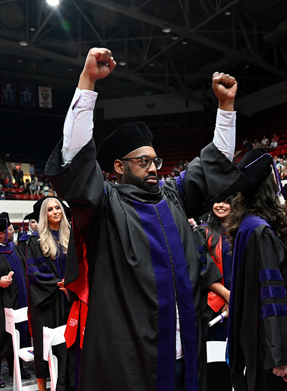A student holds up his hands during the Law ceremony.