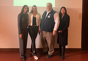 Four people pose for a photograph at a conference.