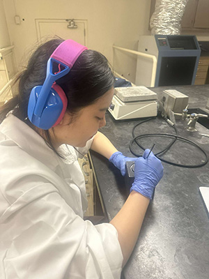 A student works on creating their medal.