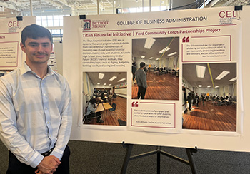 Mark Formosa stands next to a presentation poster entitled Titan Financial Initiative.