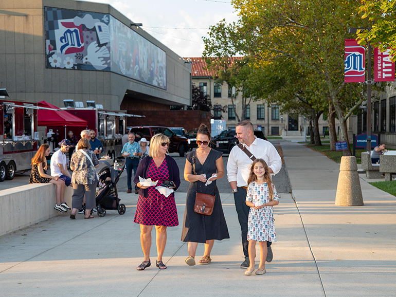 A group of people walk around Kassab Mall during Homecoming.
