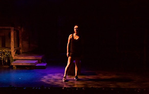 Michelle Murphy performs Keeper on a dimly lit stage.