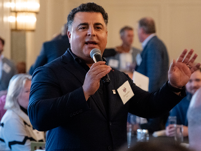 Christopher Kouza speaks with the crowd inside of his Cambria Hotel.