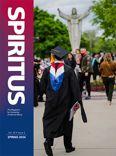 The front cover of the Spring 2024 issue of Spiritus, the magazine for University of Detroit Mercy. Volume 32, issue 2. The cover photo depicts students near the Jesus statue on the McNichols Campus at commencement.