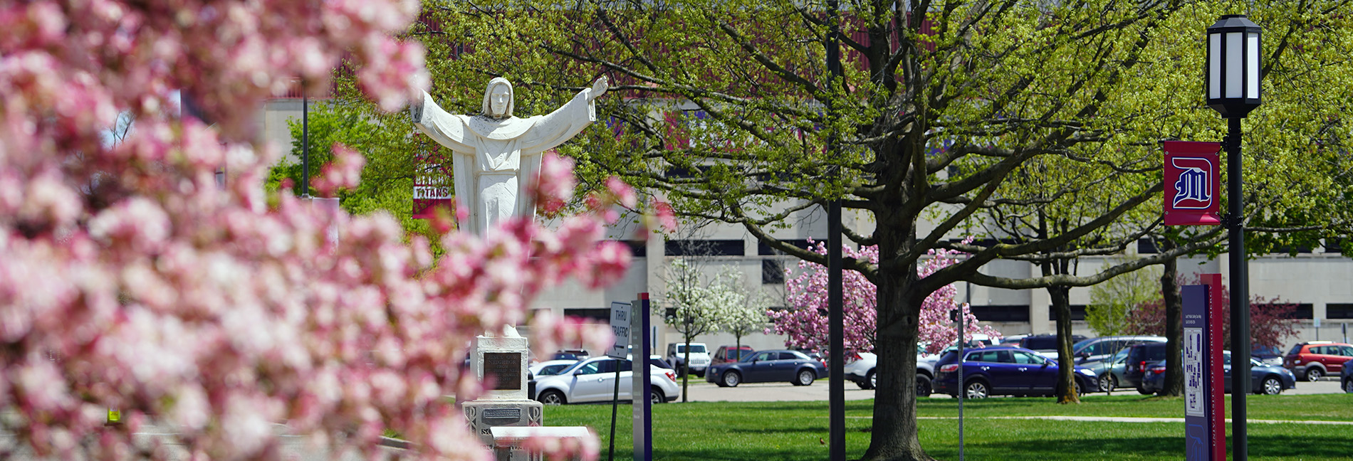A photo of the Jesus statue surrounded by spring flowers.