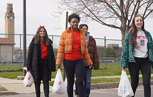 Students carry bags of groceries during a TENN delivery.