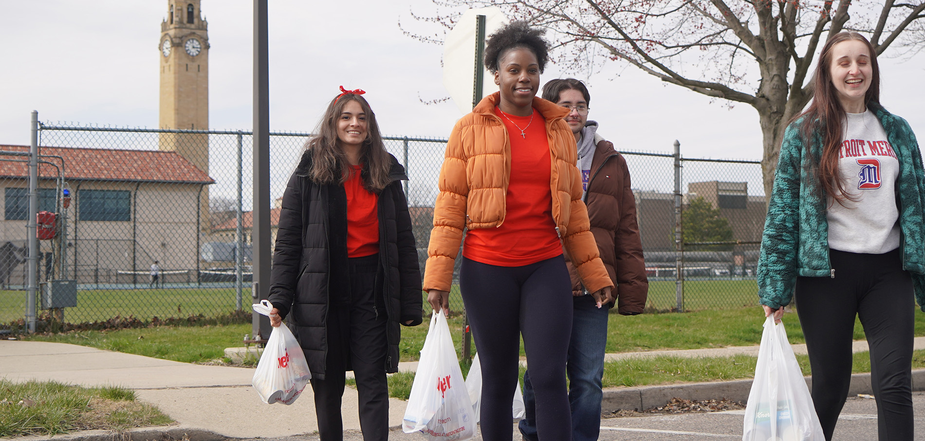 Students carry bags of groceries during a TENN delivery.