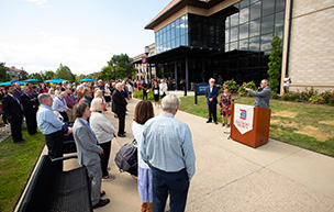 President Taylor speaks during the Whitty renaming ceremony, as a large crowd gathers around him and the Whittys.