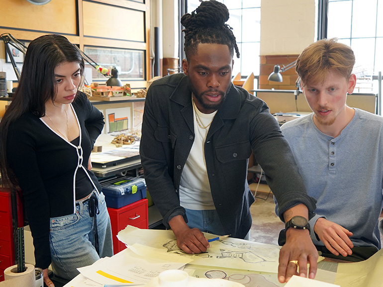 A faculty member and two students work in an architecture lab.