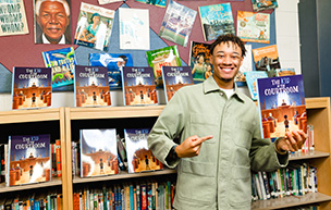 Cayden Brown holds his book "The Kid in the Courtroom" in a Library.