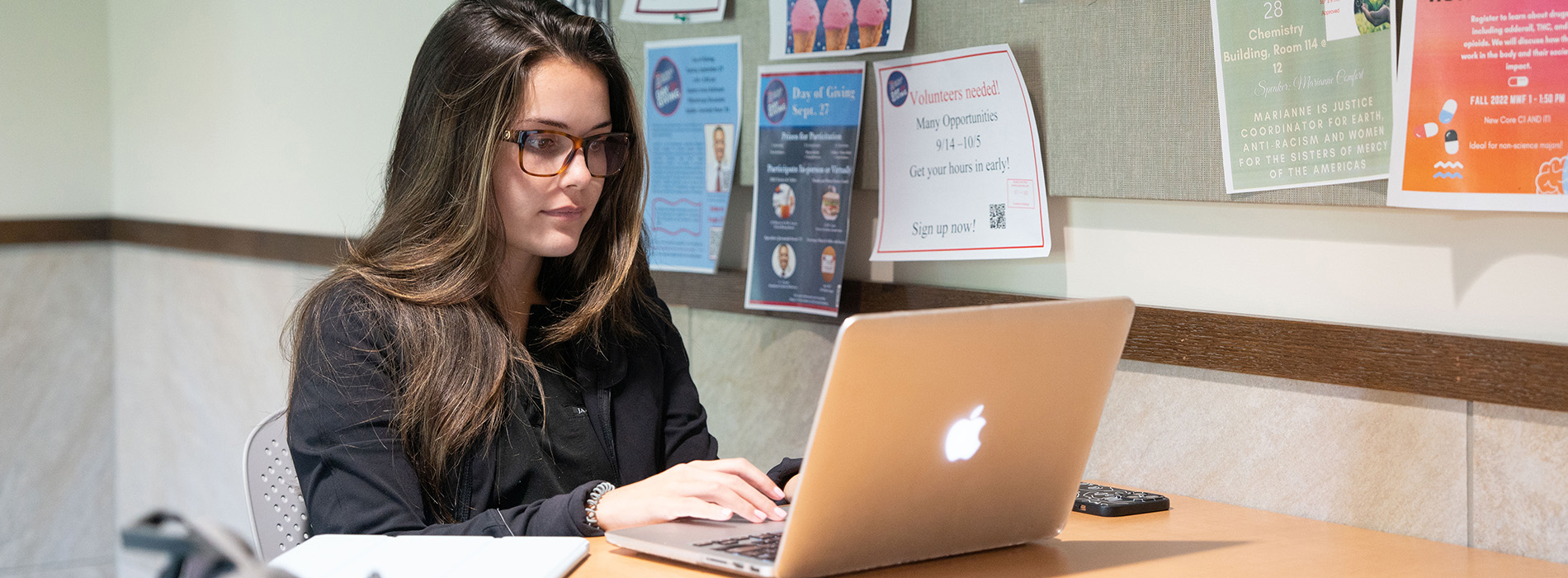 A student sits in CHP on a laptop.