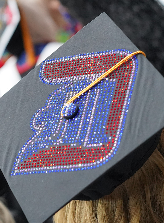 A commencement cap decorated like the UDM logo in beads.