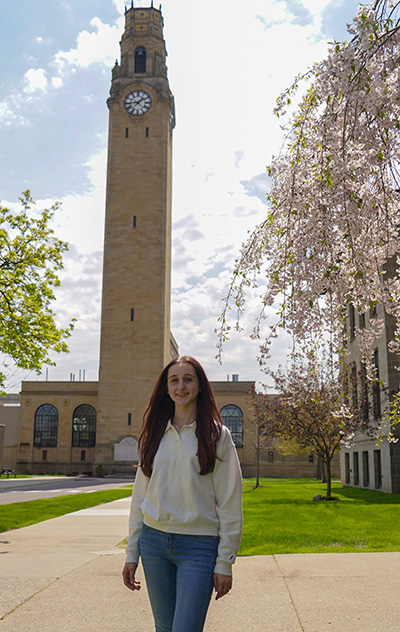 Victoria King stands in front of UDM's clocktower.