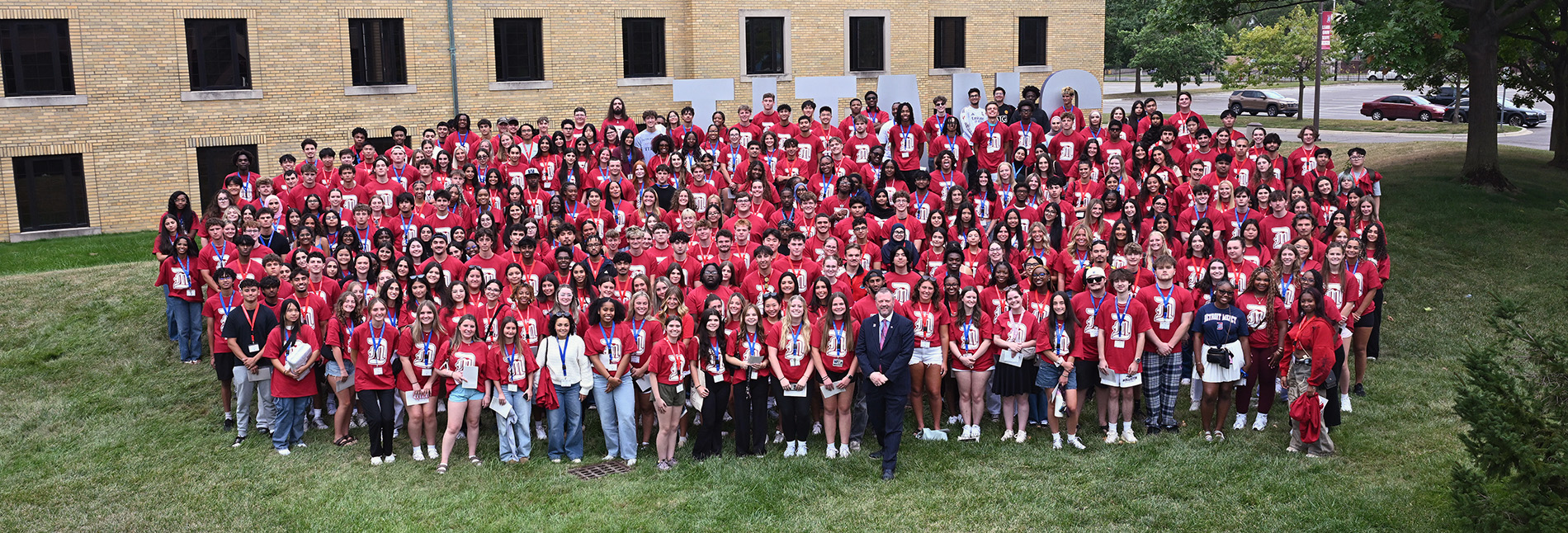 Freshmen in the Class of 2030 gather in front of the Titan sign for a photo with President Taylor.