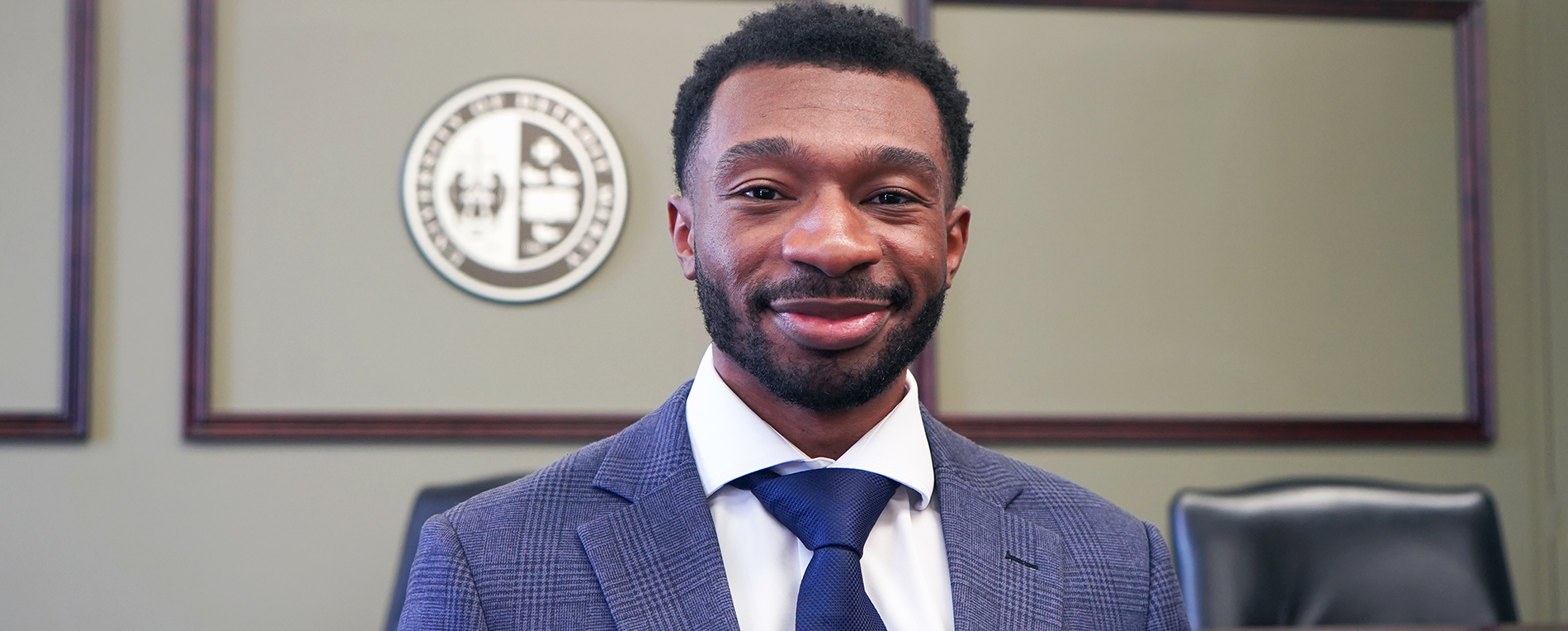 Andre Williams stands inside of a court setting at Detroit Mercy Law.