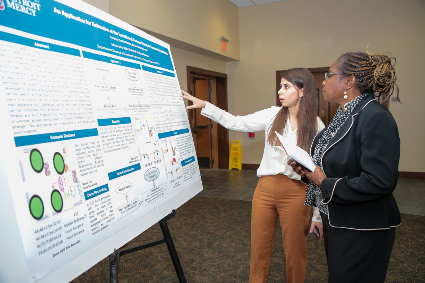 picture of student presenting research to faculty member
