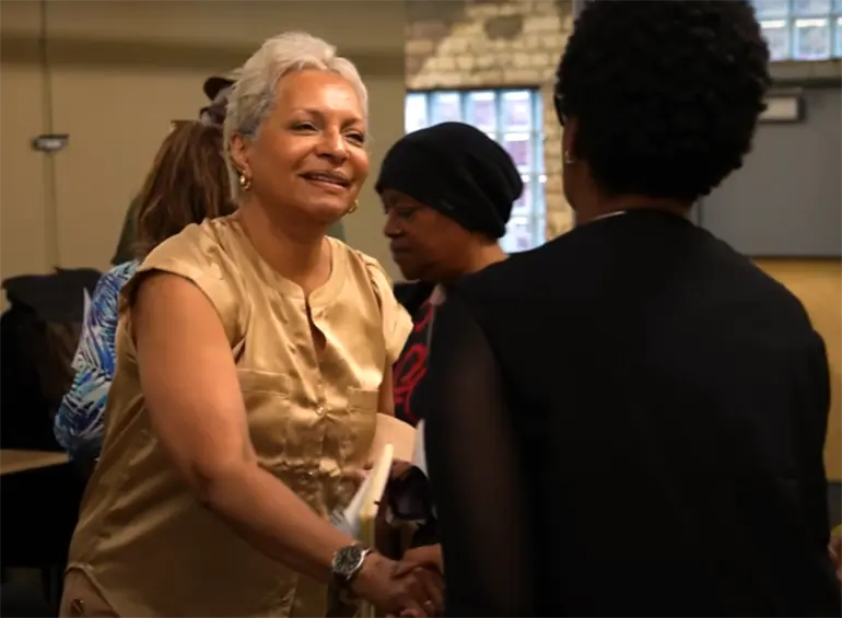 community member shaking hands with someone at a community forum event