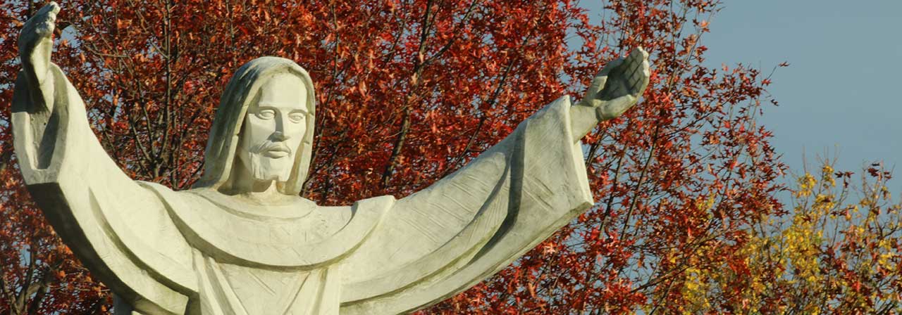 Jesus with his arms raised statue on campus