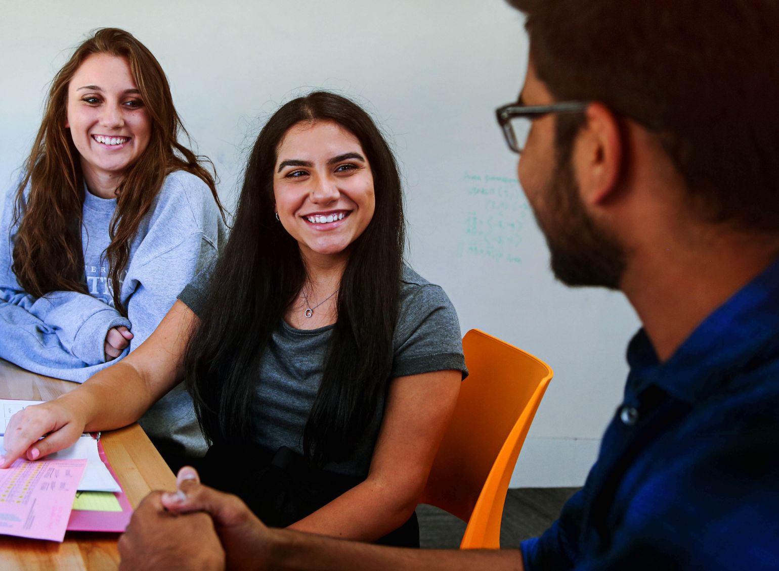 Three students smile while studying together.