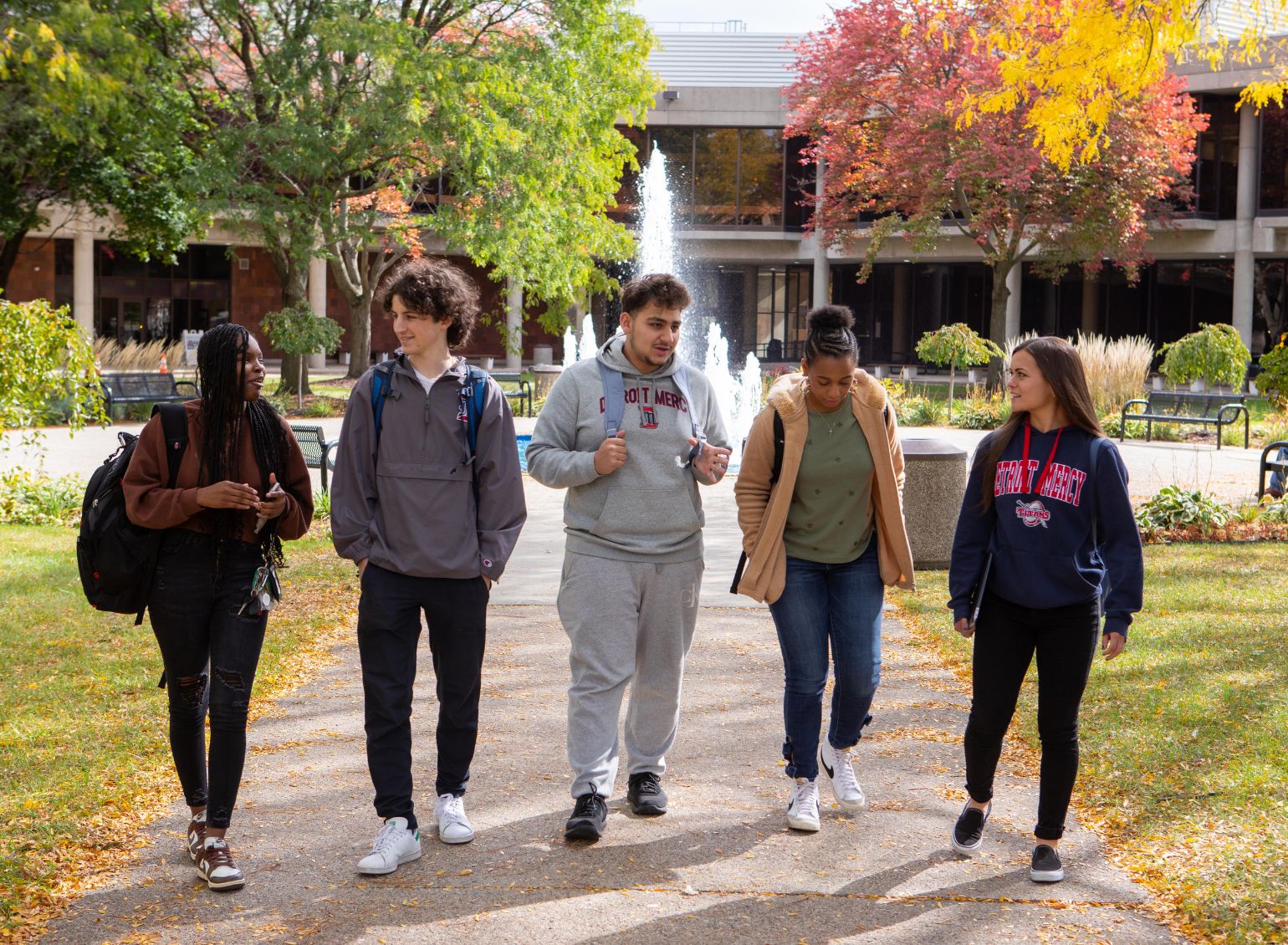 Five students walk past the Fountain.