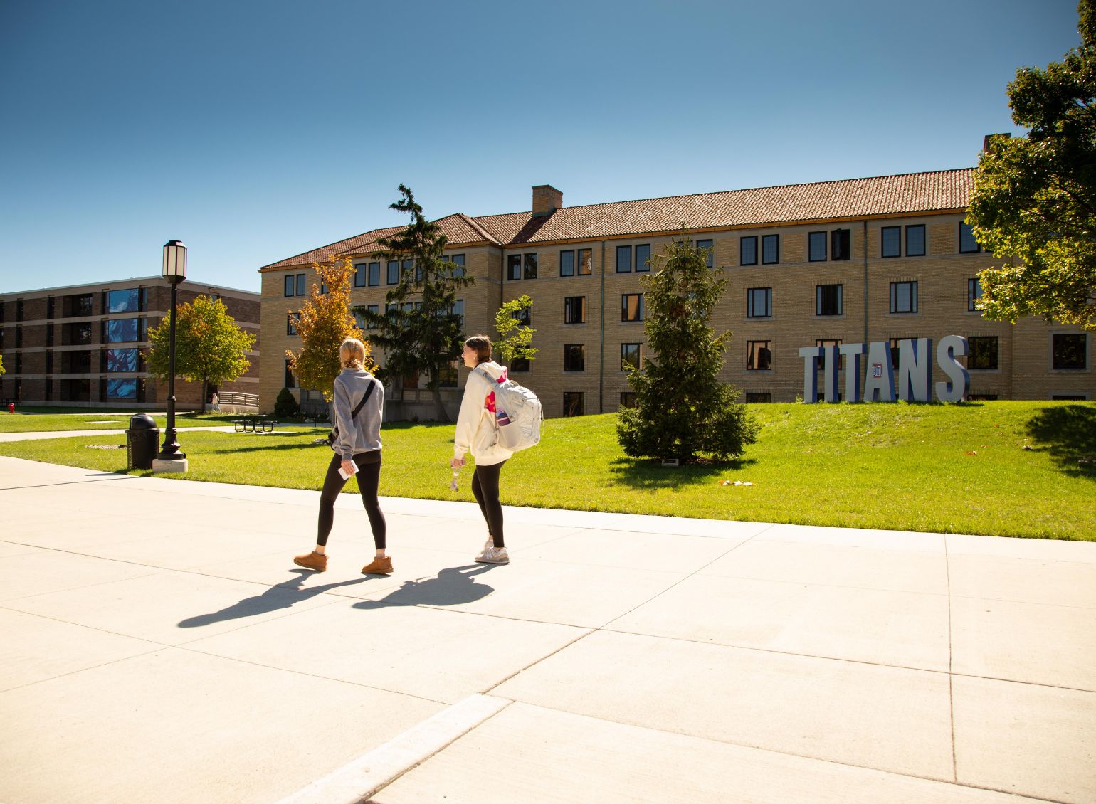 Two students walk past the Titans sign.