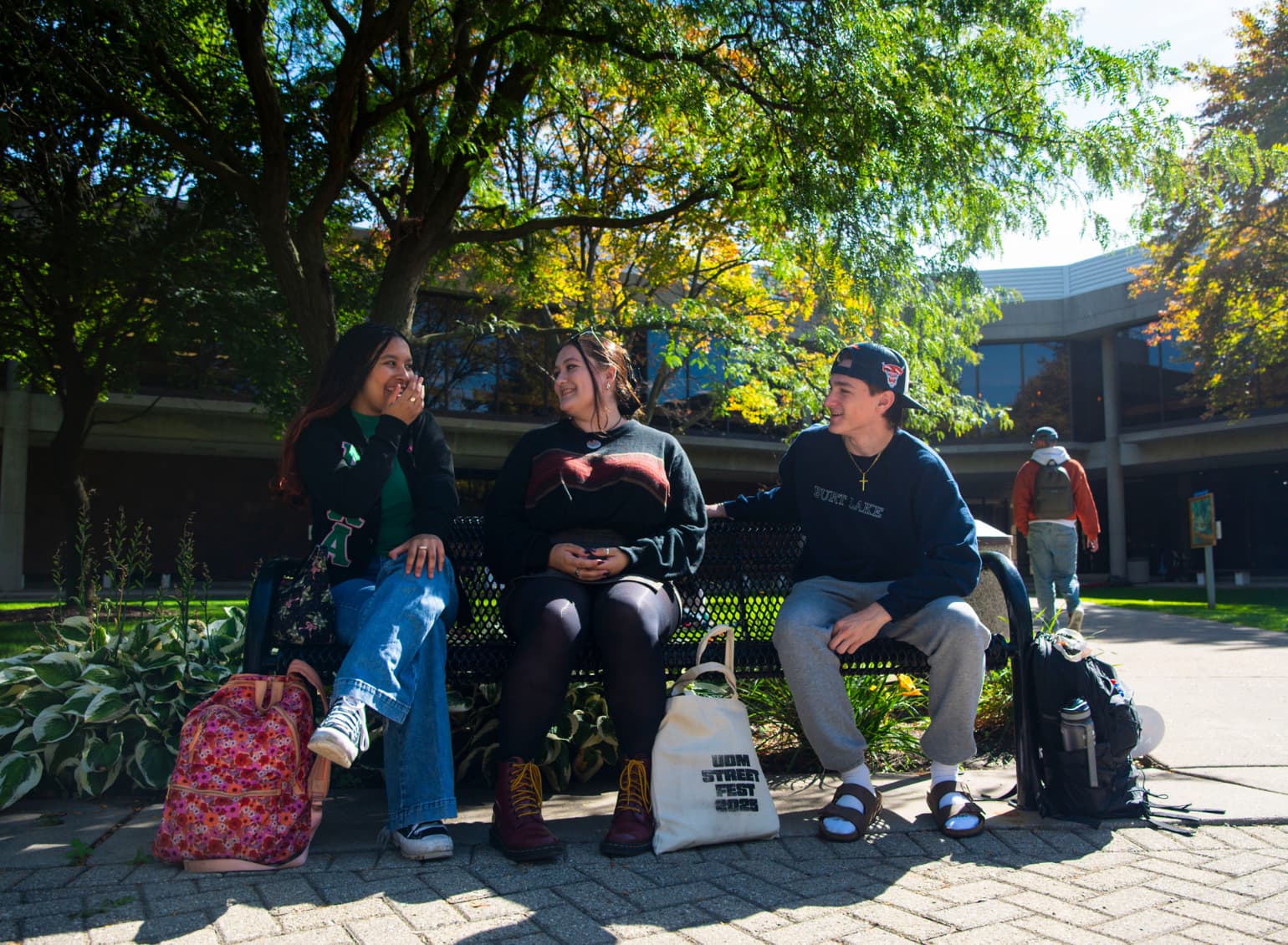Students talk on a bench on campus.