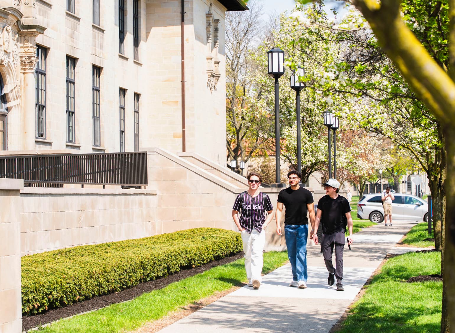 Students walk past an academic building.