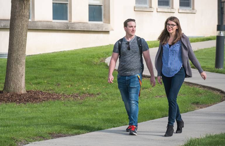 girl and guy walking on campus