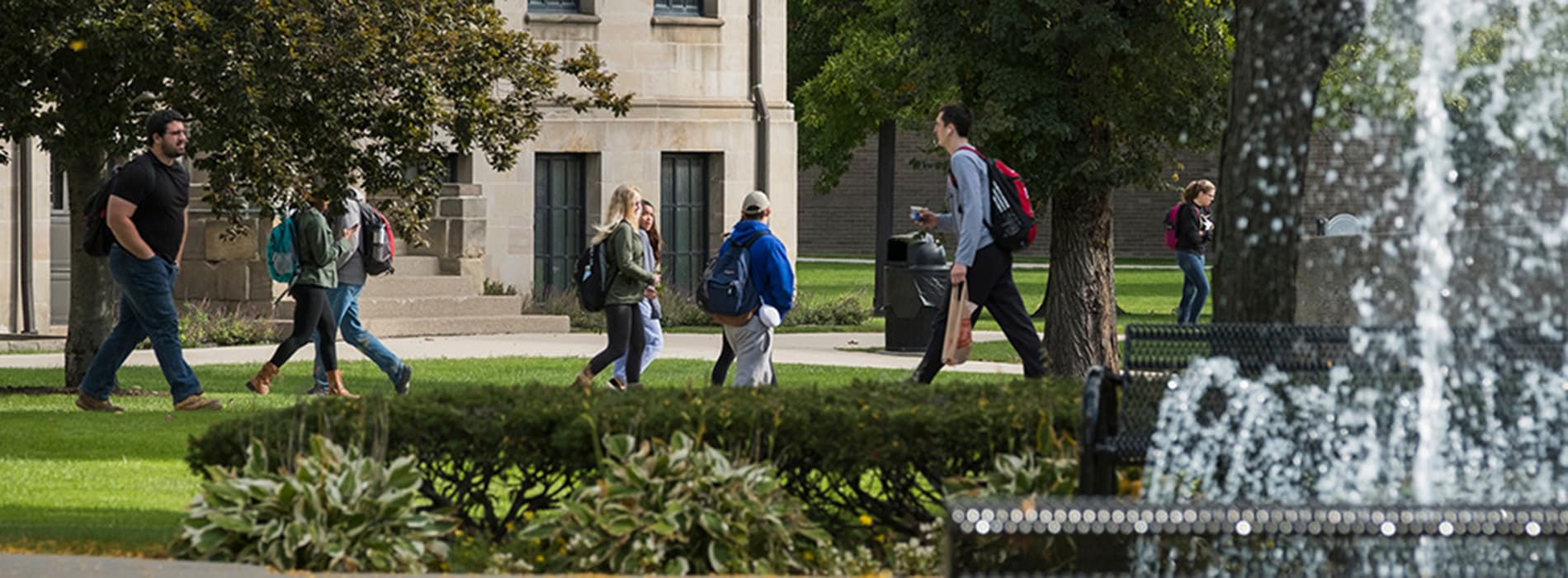 student walking by the fountain