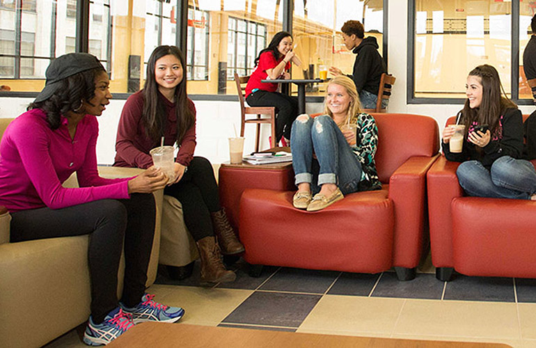 Students sitting in the Fitness Center Lounge laughing