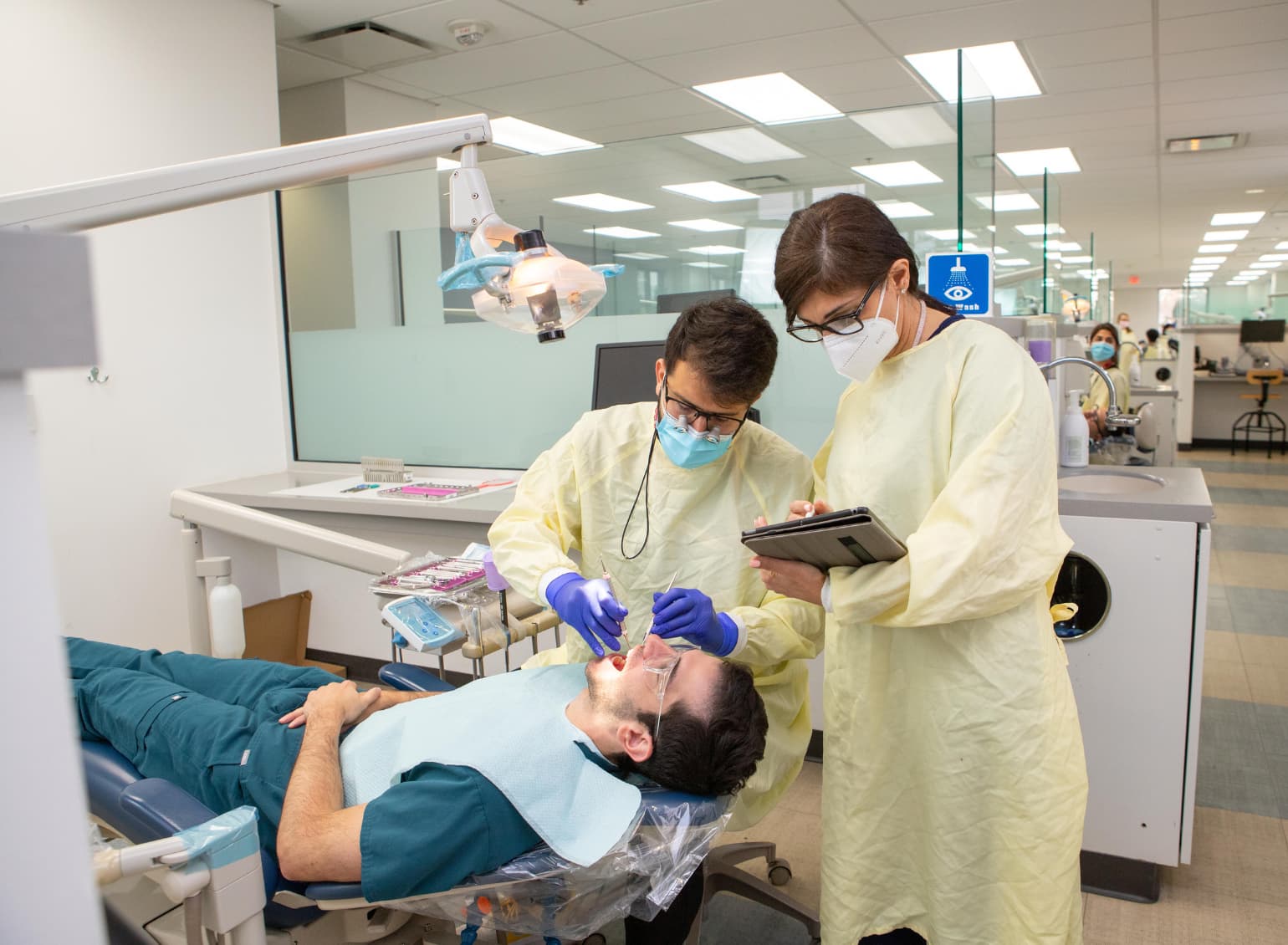 A dental student examines a patient in the dental clinic.