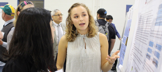 Student explaining her research at the Symposium