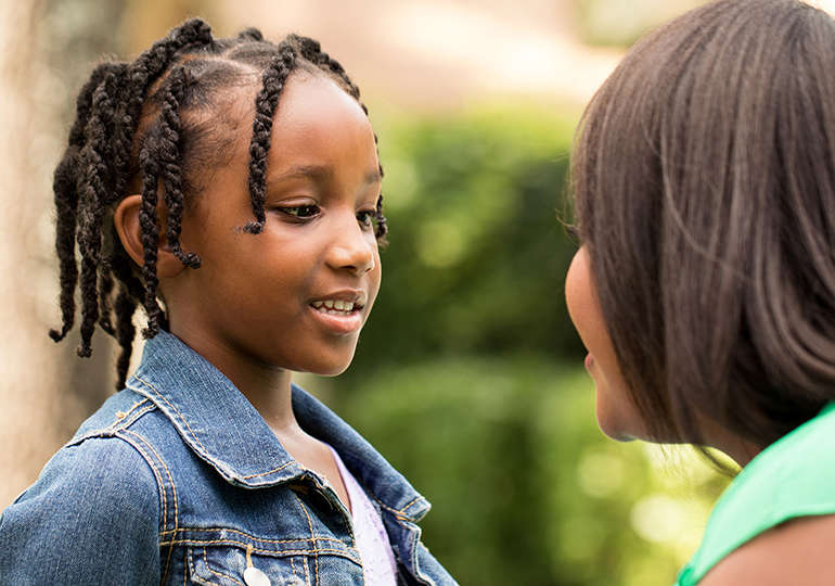 stock photo of child speaking to an adult