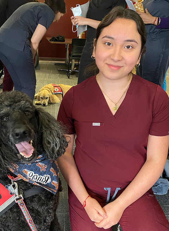 Jeanette Andrade with a dog inside of the Dental school.