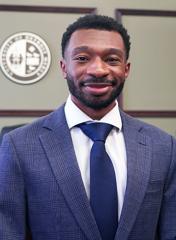 Andre Williams stands inside of a court room setting at Detroit Mercy Law.