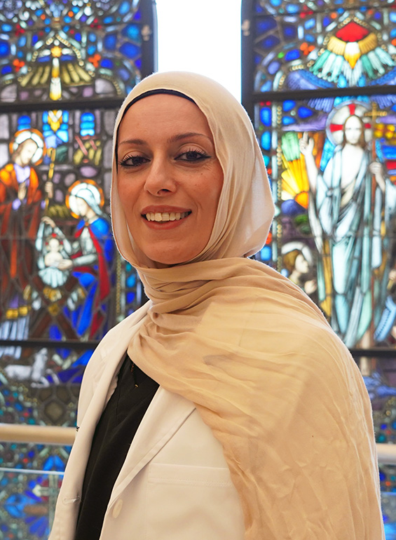 Shreen Marini stands in front of the stained glass in CHP.