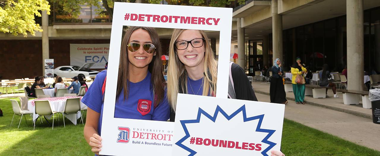 Students holding up a sign that says #DetroitMercy Boundless