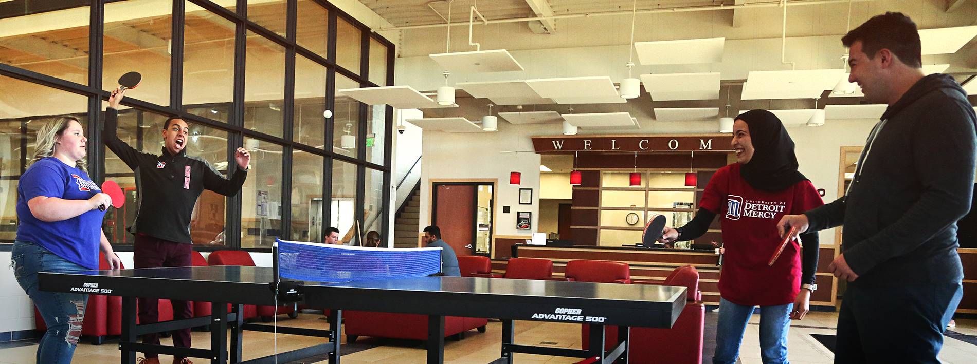 Group of students in the Student Fitness Center playing ping pong.