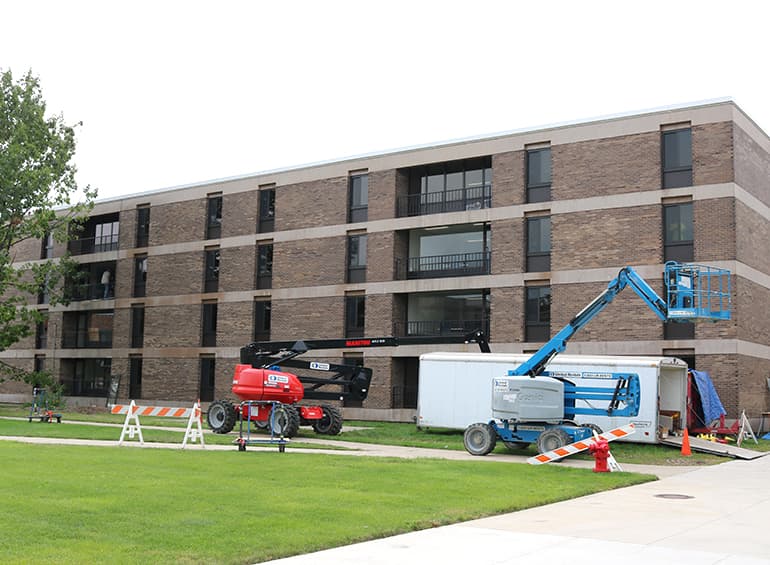 workers replacing windows outside north quad