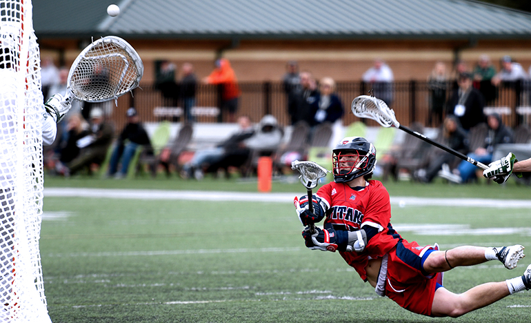 Detroit Mercy Titans Men's lacrosse player dives to score a goal.