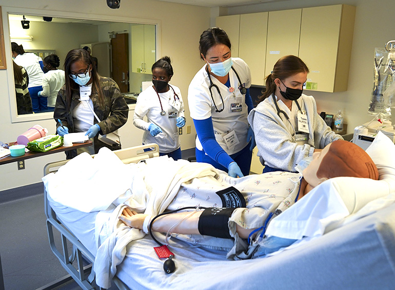 nursing students working on manikin in sim lab