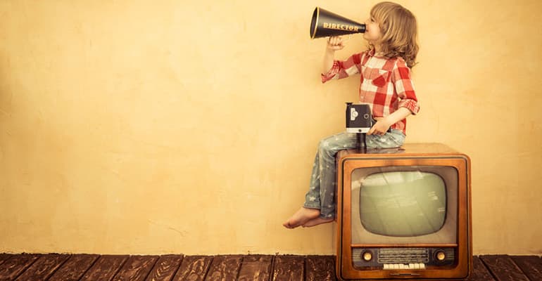 kid sitting on old tv console yelling through a megaphone