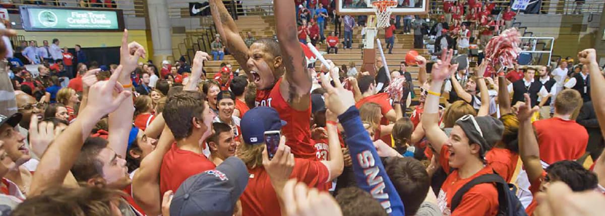 player excited for a big win surrounded by a detroit mercy crowd of fans