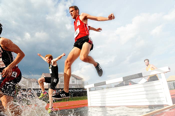 man jumping over a race barrier