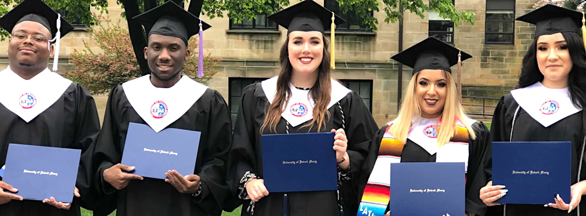 grads from the trio progam showing their diplomas