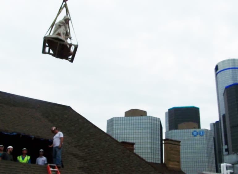 Pieta statue being lifted out of roof