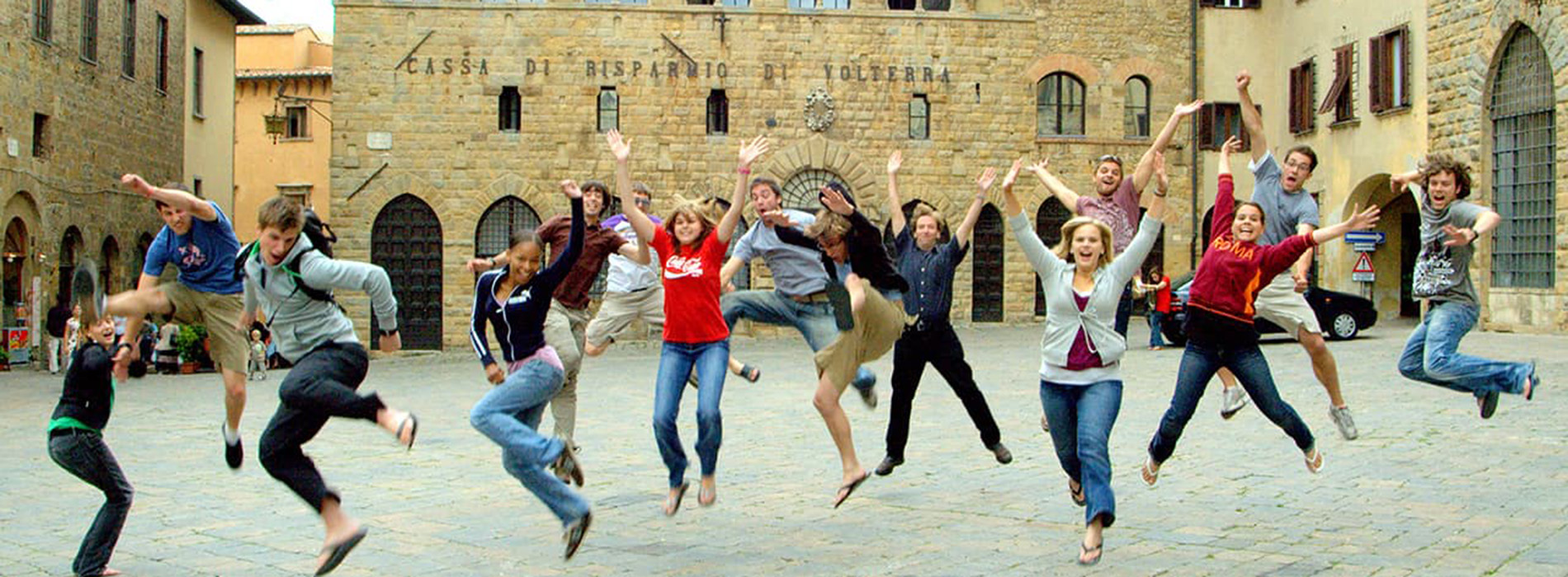 Students jumping in air in front of ancient building